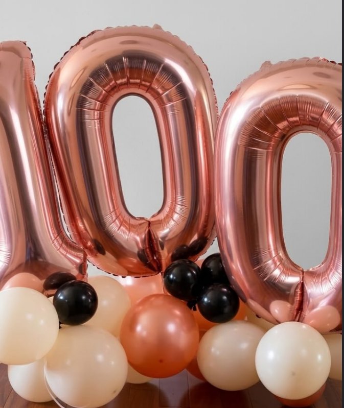 Rose gold 100 number balloons with cream, copper and black balloon clusters